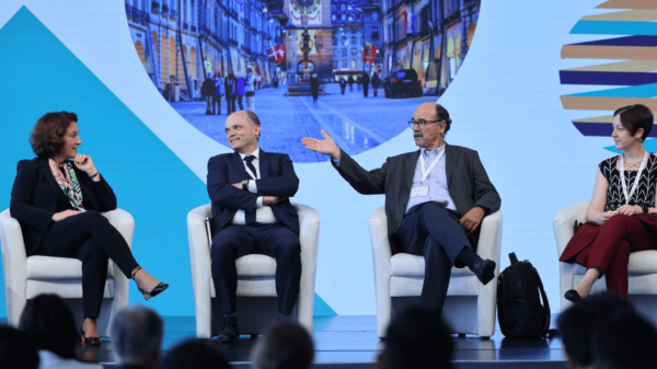 A panel of 4 people in total, 2 women and 2 men, one of whom is Bernard Hoekman sitting in the middle right, discussing during the World Trade Forum